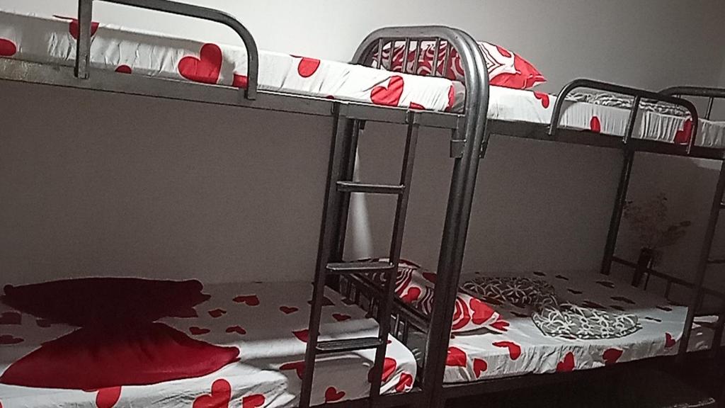 a room with two bunk beds with red hearts at Affordable bedspacer good for 8 with breakfast in Clarin