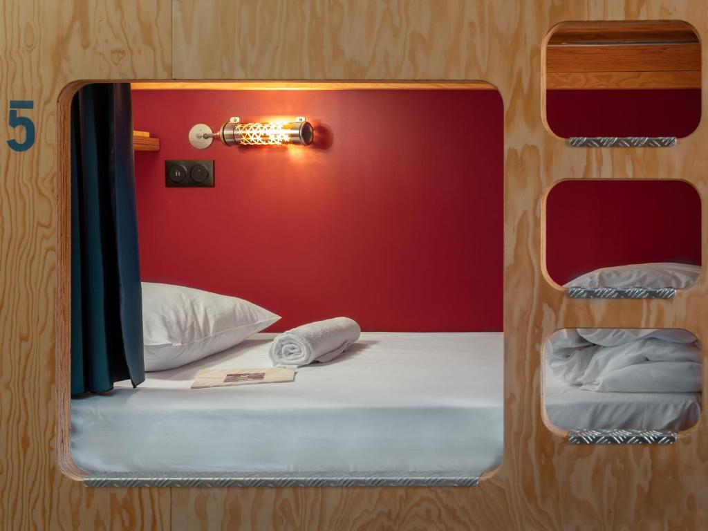 a mirror reflecting a bed in a room at Eklo Paris Expo Porte de Versailles in Vanves