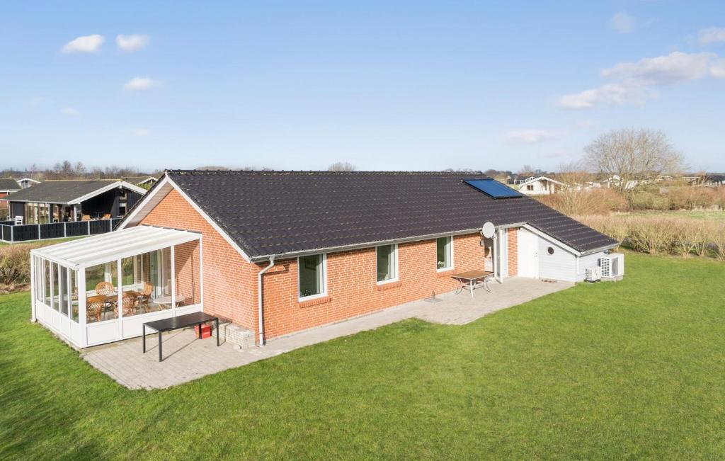 ein rotes Backsteinhaus mit großem Garten in der Unterkunft Four-Bedroom Holiday Home In Sydals in Skovbyballe