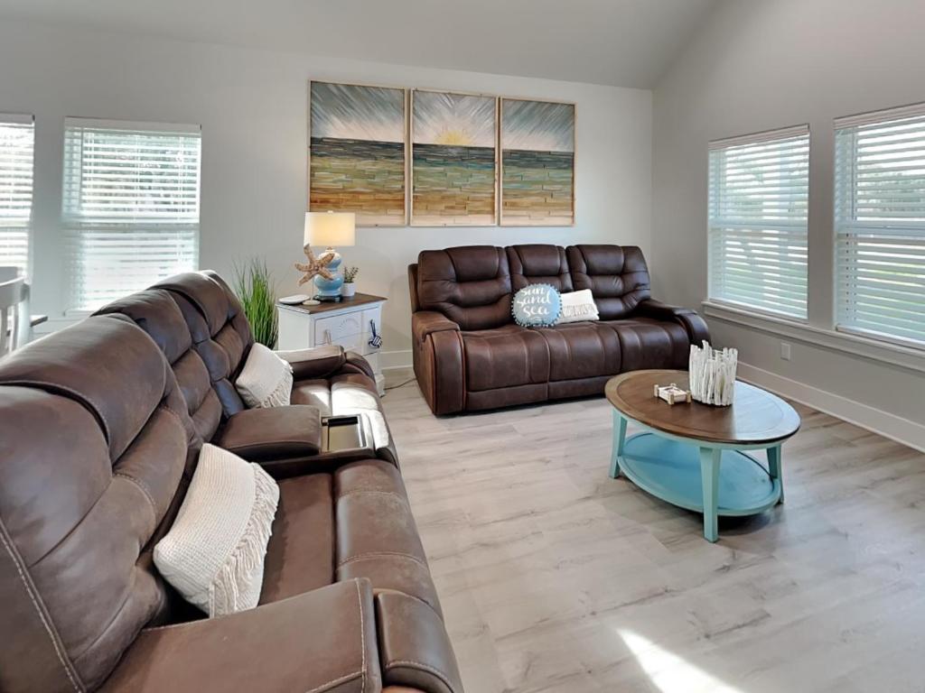 un soggiorno con un divano in pelle e un tavolo di Holiday Hideaway a Rockport