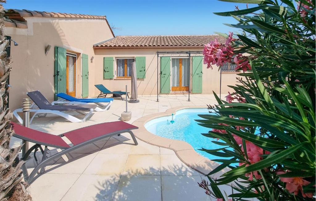 une terrasse avec une piscine et des chaises ainsi qu'une maison dans l'établissement Pet Friendly Home In Pouzols-Minervois, à Pouzols-Minervois
