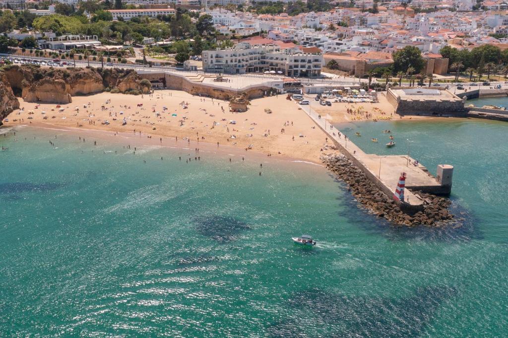 an aerial view of a beach with people in the water at Fábrica da Ribeira 60 by Destination Algarve in Lagos