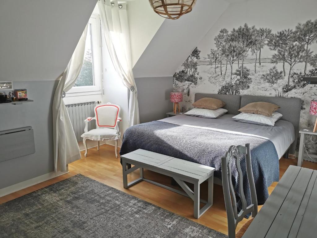 サン・マロにあるPlage du Pont - Chambres d'Hôtesのベッドルーム1室(ベッド1台、テーブル、椅子付)