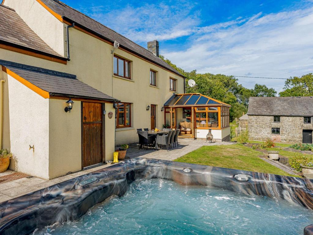 een huis met een zwembad in de tuin bij 5 Bed in Aberystwyth 58889 in Llanrhystyd