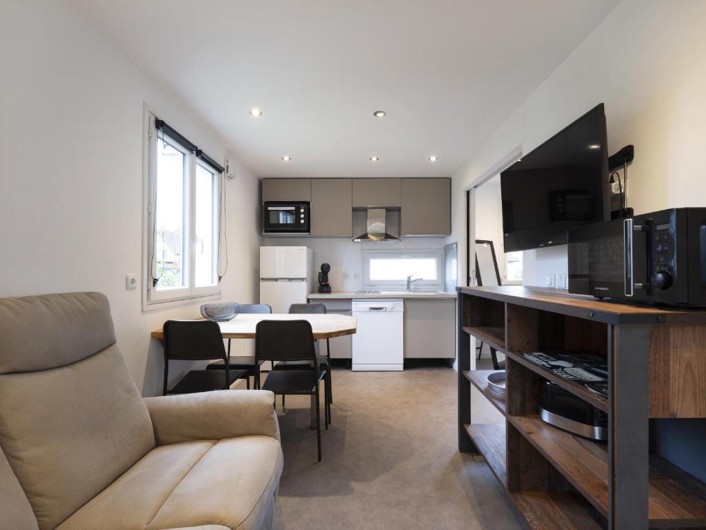 cocina y sala de estar con sofá y mesa en Residence Louis Quartier Des Lilas en Vittel