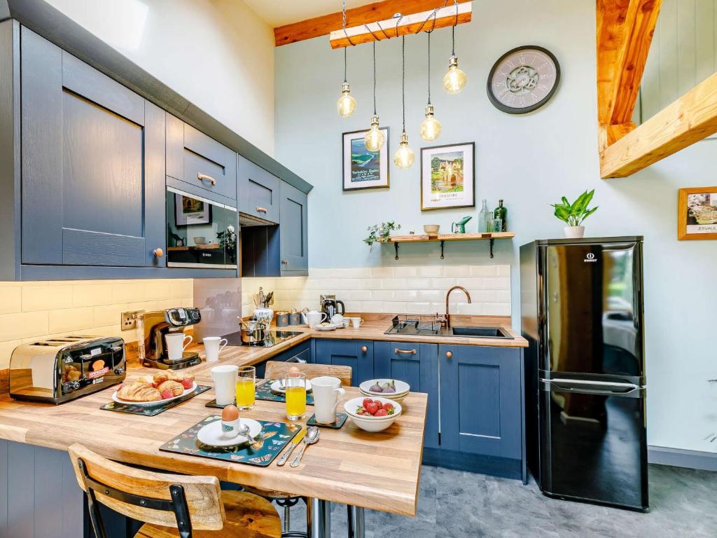 a kitchen with blue cabinets and a wooden table at 1 bed in Masham 85511 in Masham