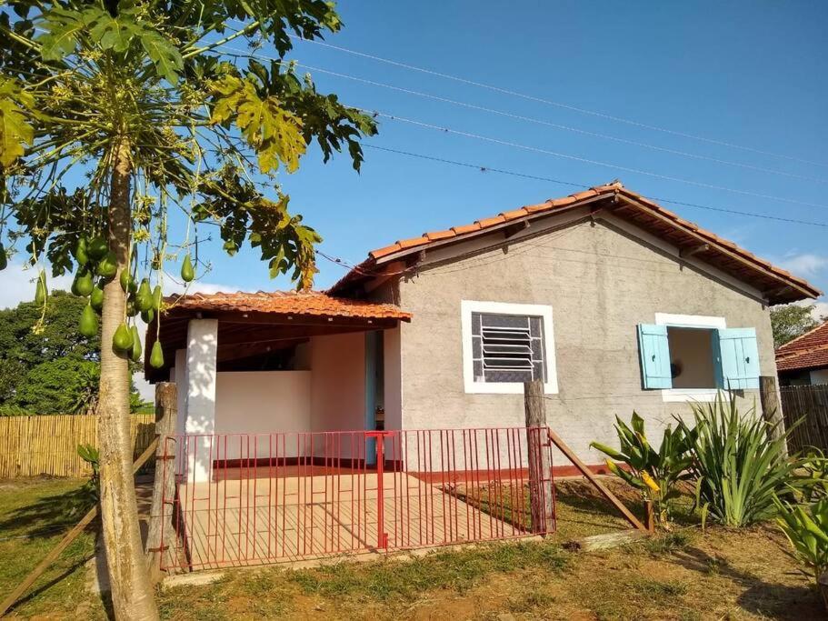 une maison avec une clôture rouge devant elle dans l'établissement Casinha Original de Fazenda, à Araras