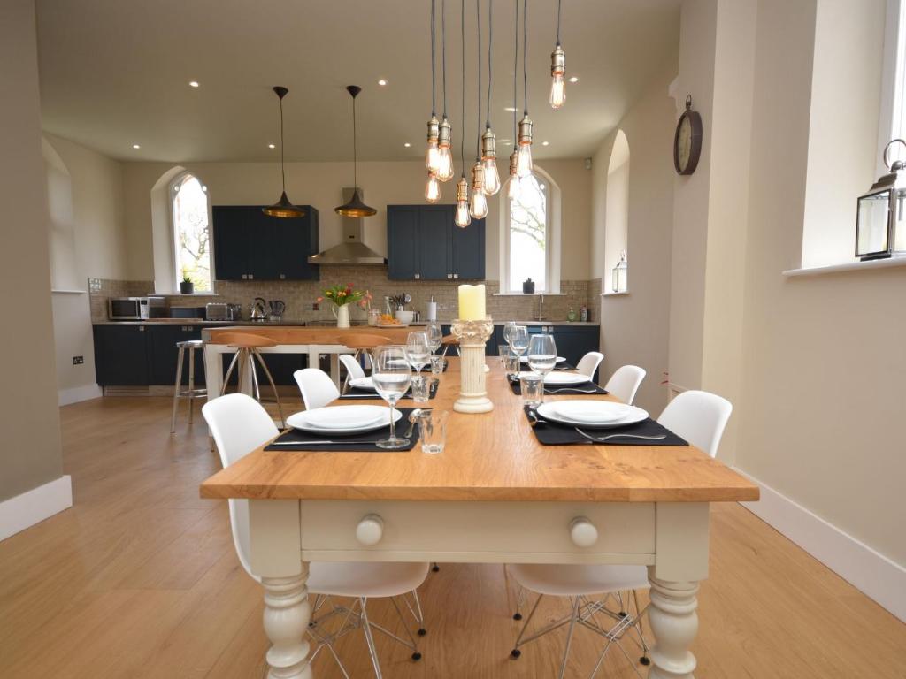 a dining room with a large wooden table and white chairs at 2 bed in Alford 42581 