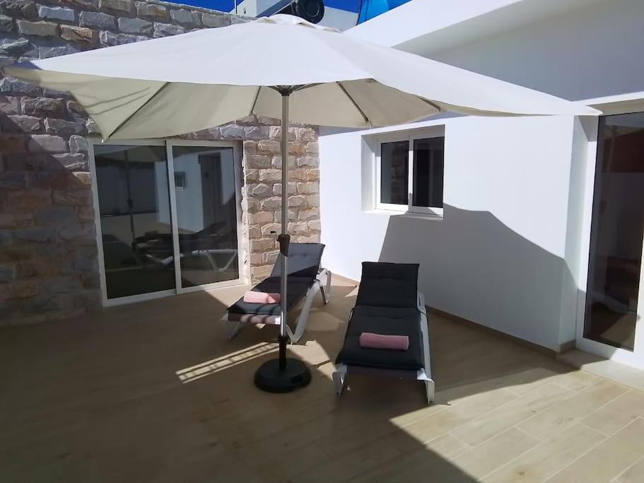 a white umbrella and two chairs in a room at La Catumbela in Tuineje