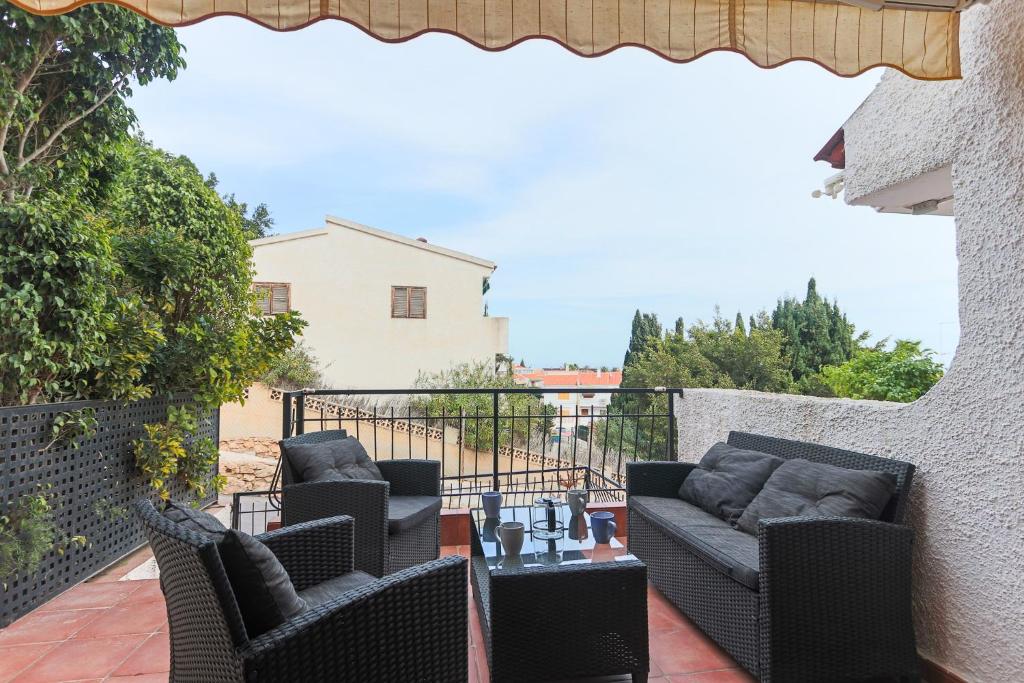 un patio con 2 sillas y una mesa en el balcón en 022 - Las Palmeras III - 001 - comfortHOLIDAYS, en Santa Pola