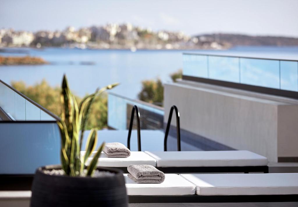 a table with two towels and a plant on a balcony at The Sand Villa in Agios Nikolaos