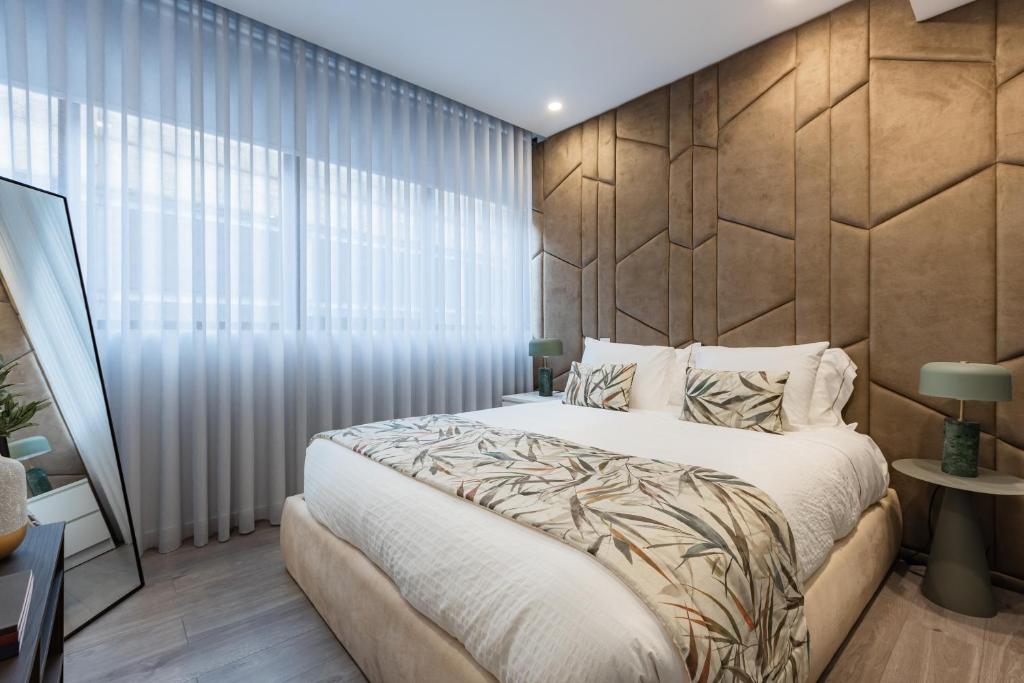 a bedroom with a large bed and a large window at Boavista Executive Studios in Porto