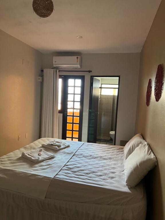 a bedroom with a large bed with two towels on it at Pousada Solar da Praia Maragogi in Maragogi