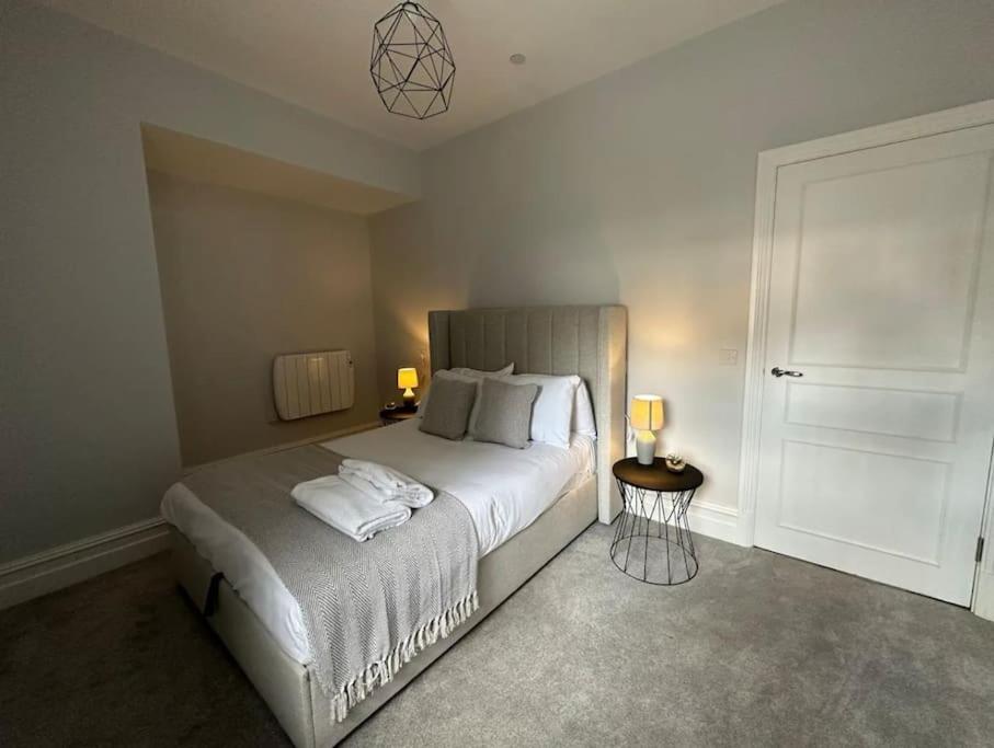 a bedroom with a large bed with two lamps on it at Superior Stay, Sophia Gardens, City Centre and Stadium Sleeps 4 in Cardiff