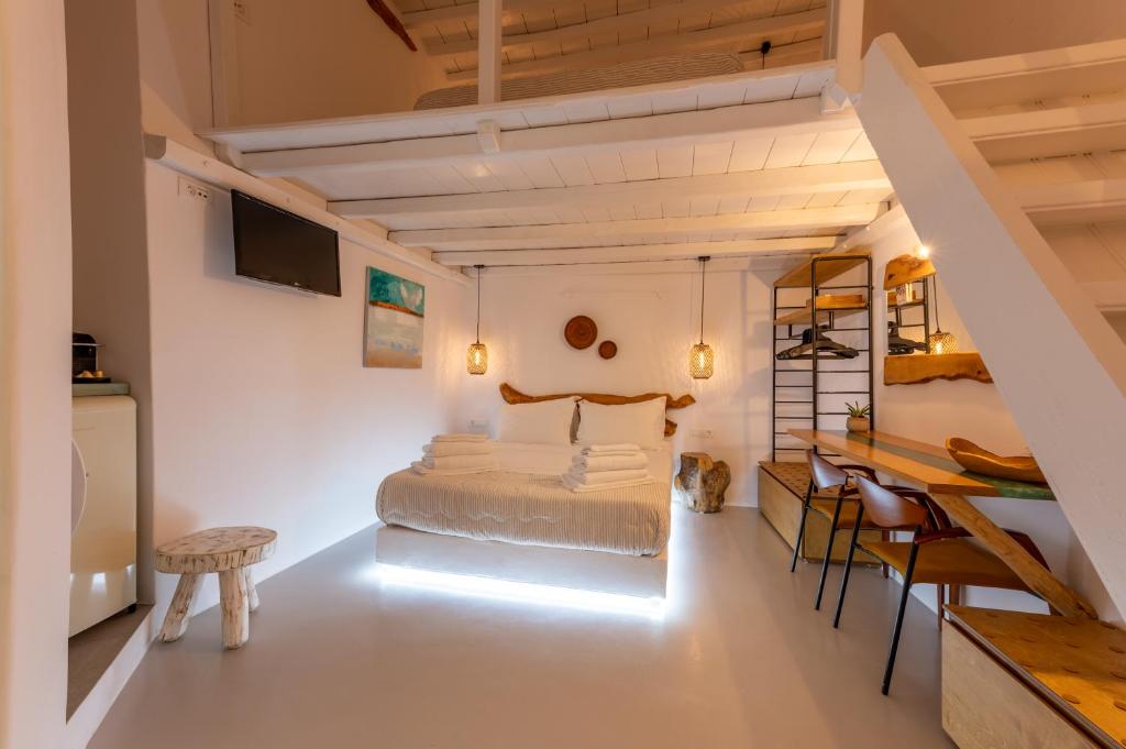 Un dormitorio con una cama y una mesa y sillas. en MYKONOS VIBES TOWN LOFT, en Mykonos ciudad