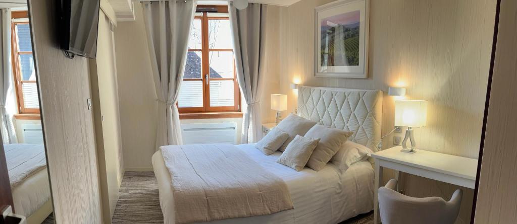 une chambre avec un lit blanc et une fenêtre dans l'établissement Logis Hôtel des Messageries, à Arbois