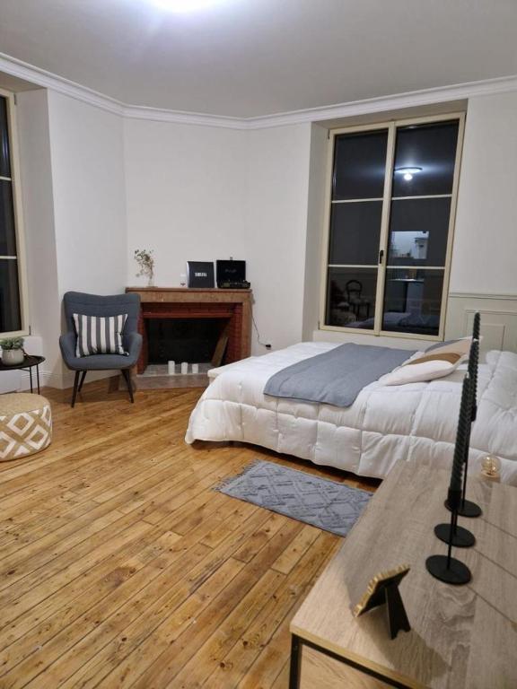 une chambre avec un lit, une chaise et des fenêtres dans l'établissement Logement Alice Wilson, à Mont-sous-Vaudrey