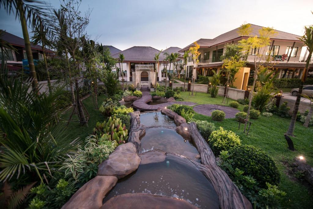 
a large stone building with a pool of water in front of it at Maryo Resort - SHA Plus in Chiang Rai
