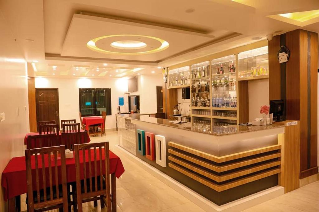 um restaurante com um bar com mesas e cadeiras vermelhas em Shrestha Hotel Hotspring PVT.LTD em Beni