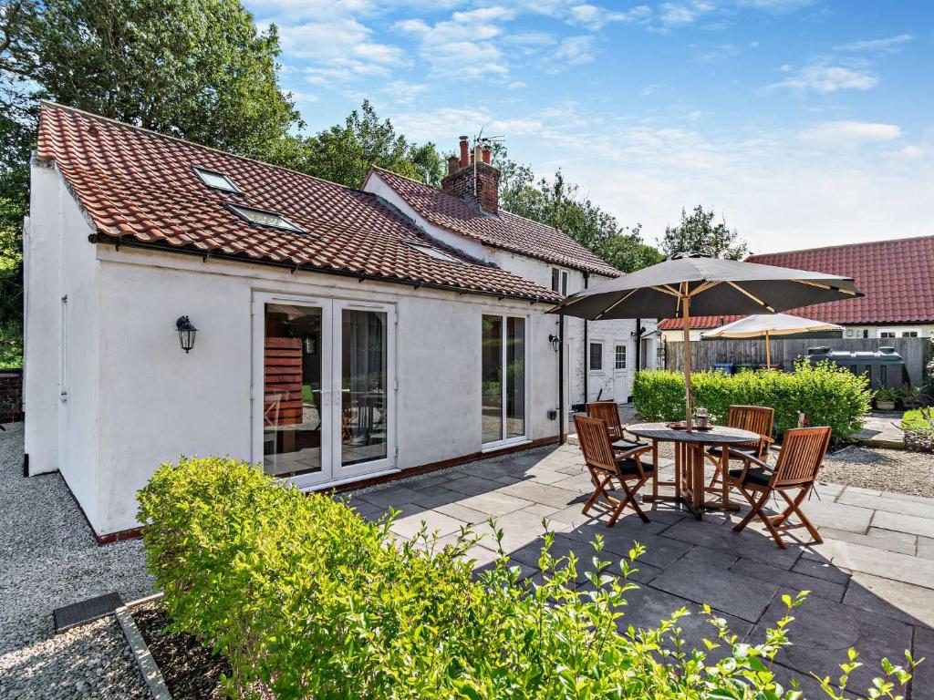 a patio with a table and chairs and an umbrella at 2 Bed in Bridlington 13mls E 93140 in Butterwick