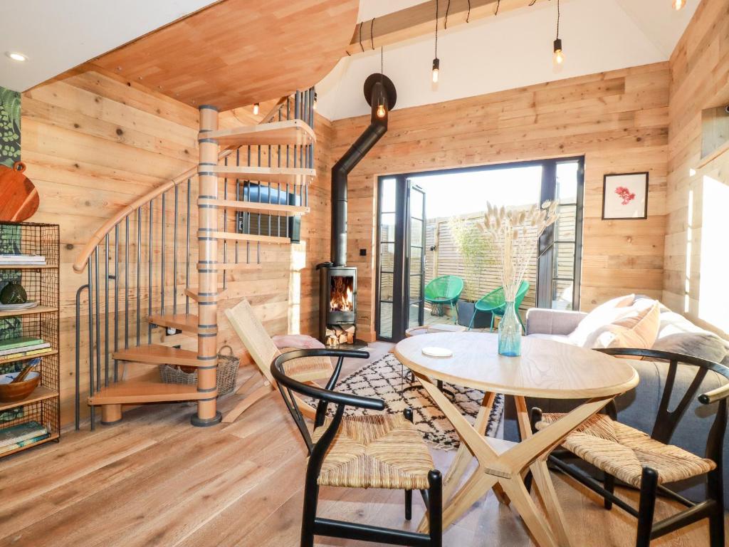Habitación con escalera de caracol, mesa y sillas en Little Beach Cabin en Newquay