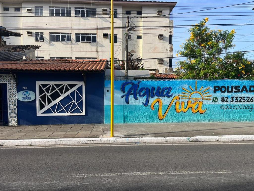 a blue wall with graffiti on the side of a street at Pousada Água Viva in Maceió