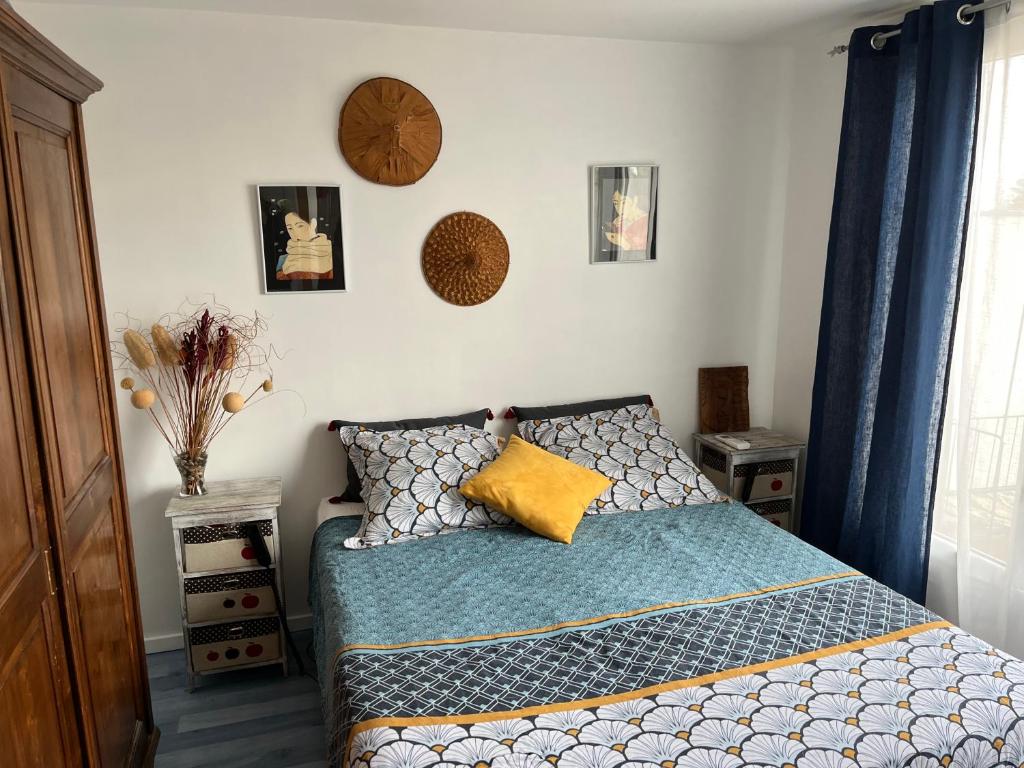 - une chambre dotée d'un lit avec une horloge murale dans l'établissement Villa Magali idéale JO 2024, à Villejuif