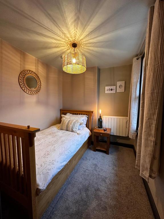 1 dormitorio con cama y lámpara de araña en The Hideaway, en Stratford-upon-Avon