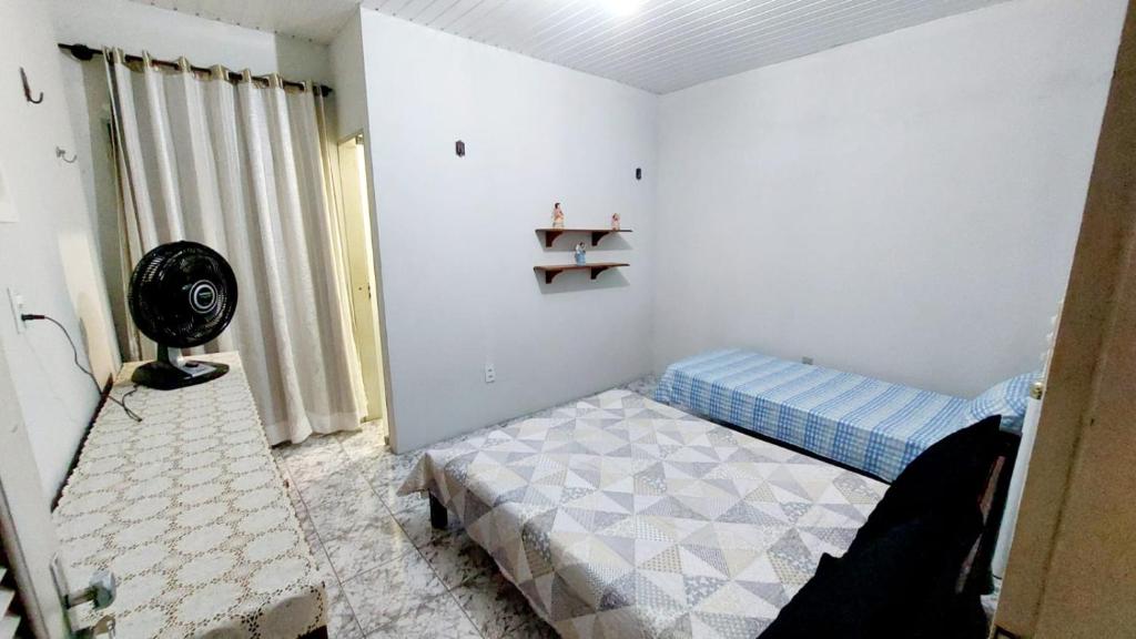 a bedroom with a bed and a fan in it at Will's House in São Luís
