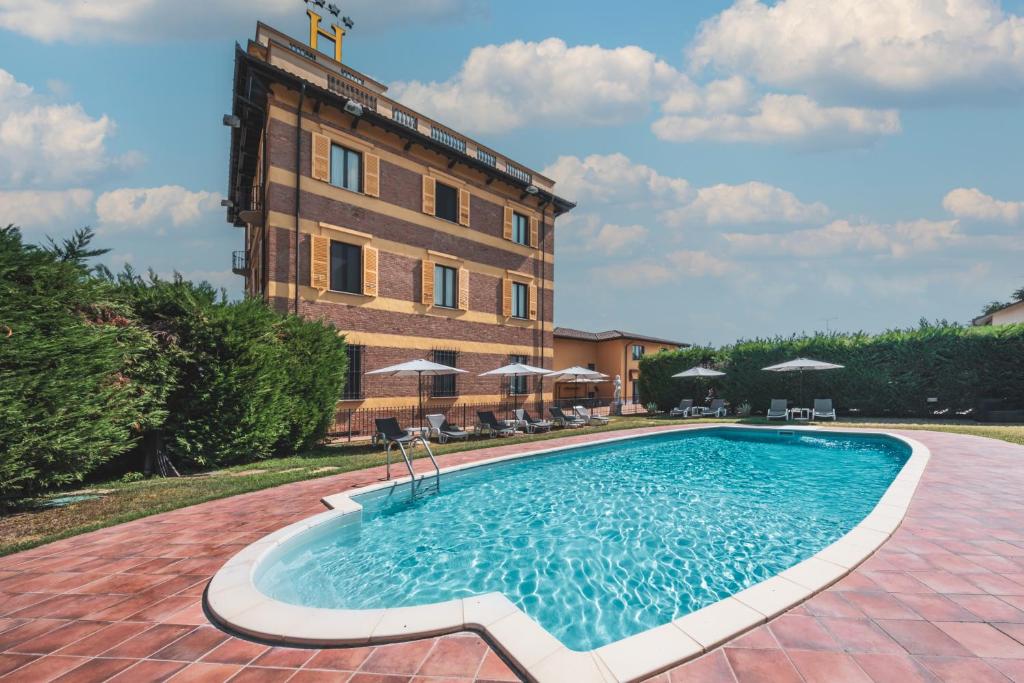 a swimming pool in front of a building at Hotel Villa Liberty in Pontecurone