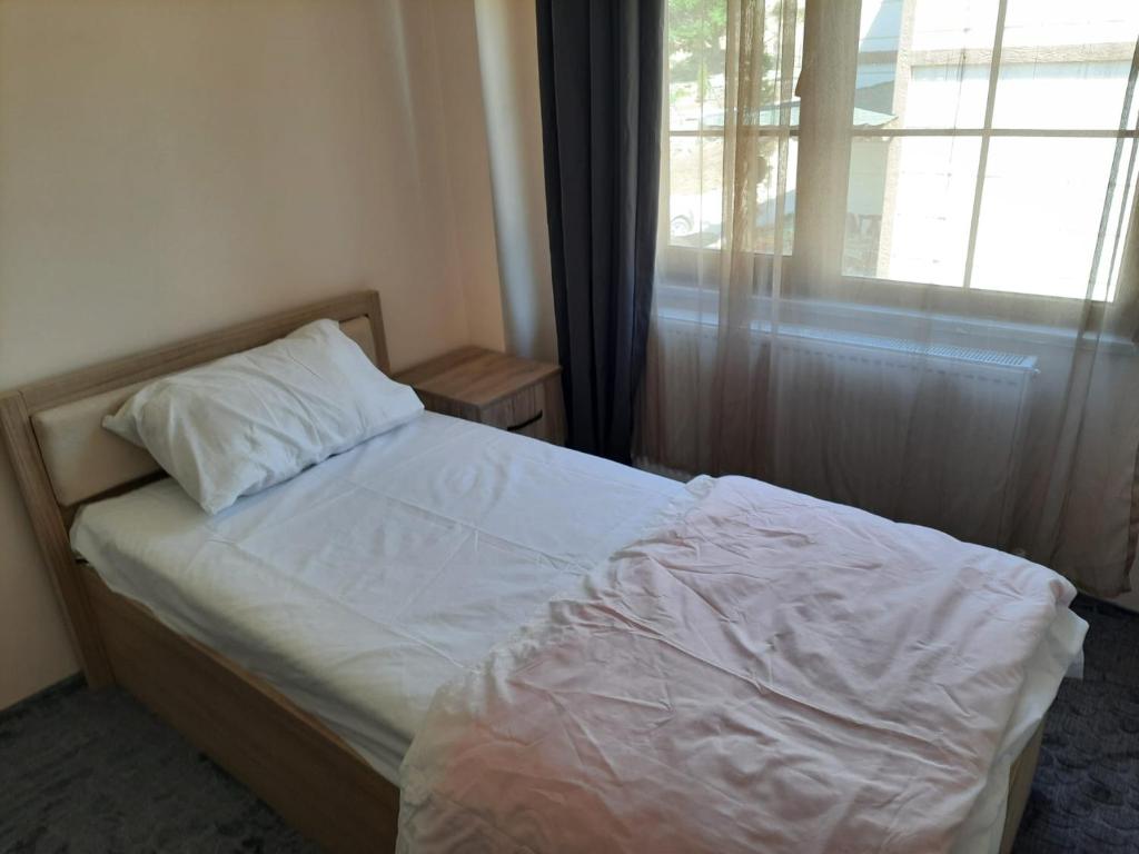 a small bedroom with a bed with a window at Yeşilgöl doğa evleri in Tokat