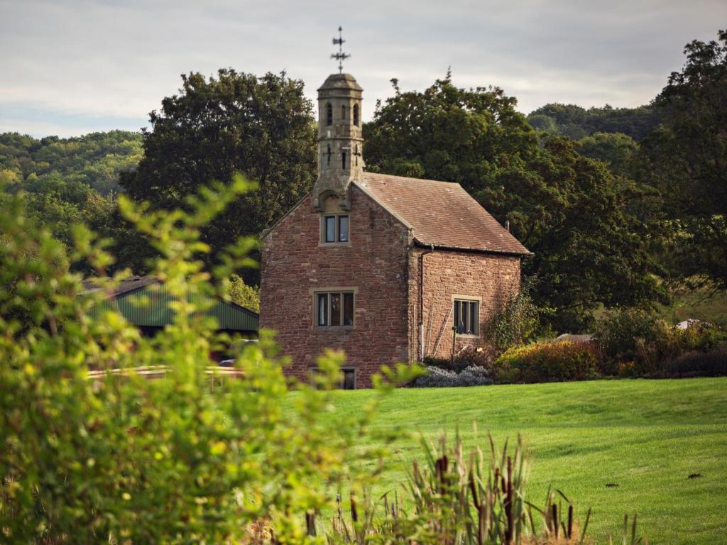 an old brick church with a tower on a field at 1 bed in Bishops Frome 75600 in Bishops Frome