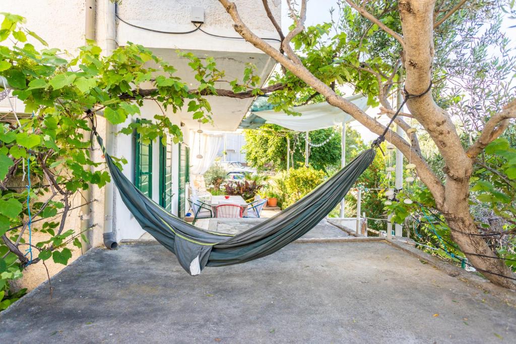 a hammock hanging from a tree outside a house at Seaview Holiday Apartments in Slatine