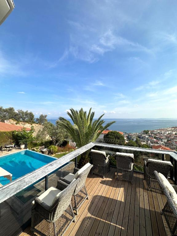 a deck with chairs and a swimming pool at Suuyla Kazdagları in Edremit