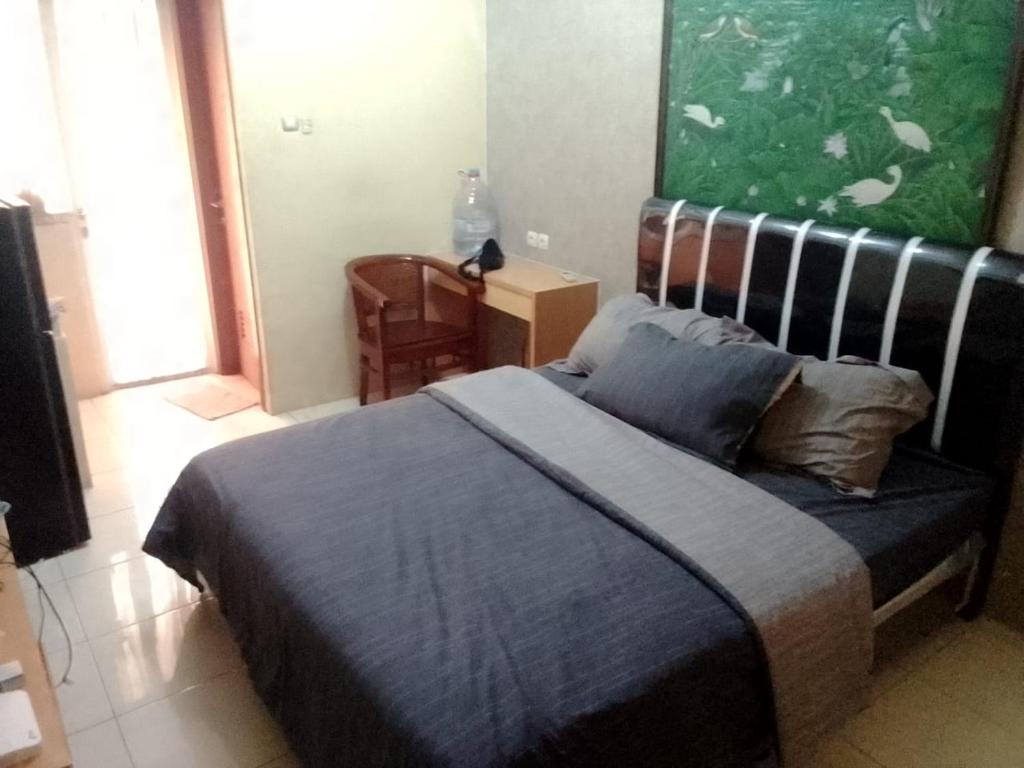 1 dormitorio con 1 cama y una gran pintura en la pared en Mega Room 69, en Pondokcabe Hilir