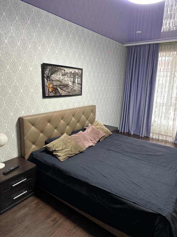 una camera da letto con un grande letto con copriletto blu di Sweet Home a Dnipro