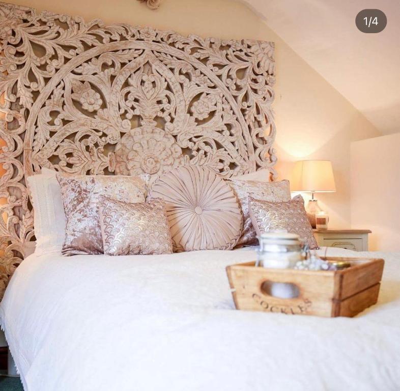 sypialnia z dużym białym łóżkiem z drewnianym zagłówkiem w obiekcie The Shepherd's Purse w mieście Whitby