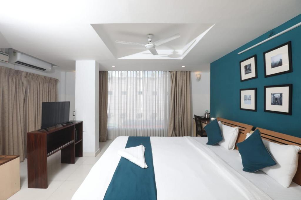 Naksha Tree Hotels, Honey Crest- Ramapuram في تشيناي: غرفة نوم بسرير كبير وتلفزيون