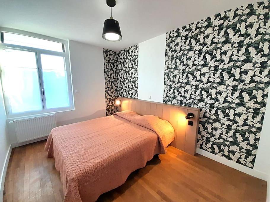 um quarto com uma cama e uma grande janela em Jolie Maison 3 chb- 7 lits- jardin em Levroux