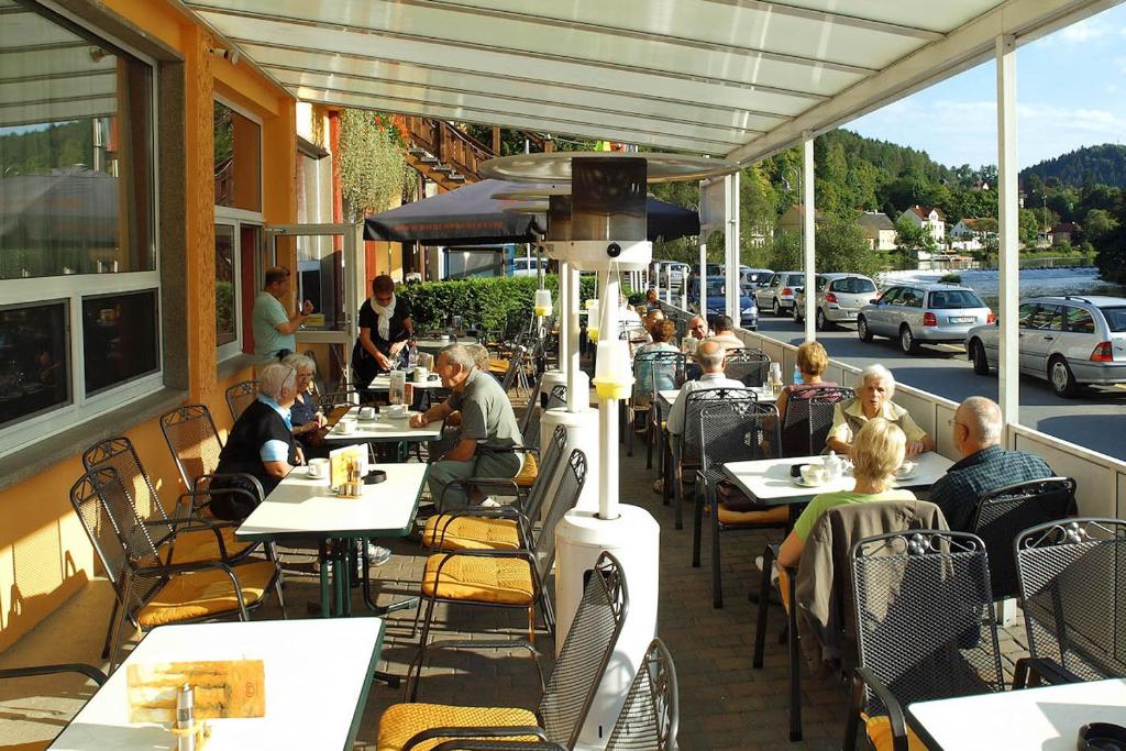 a group of people sitting at tables outside a restaurant at Hotel Am Schlossberg in Ziegenrück