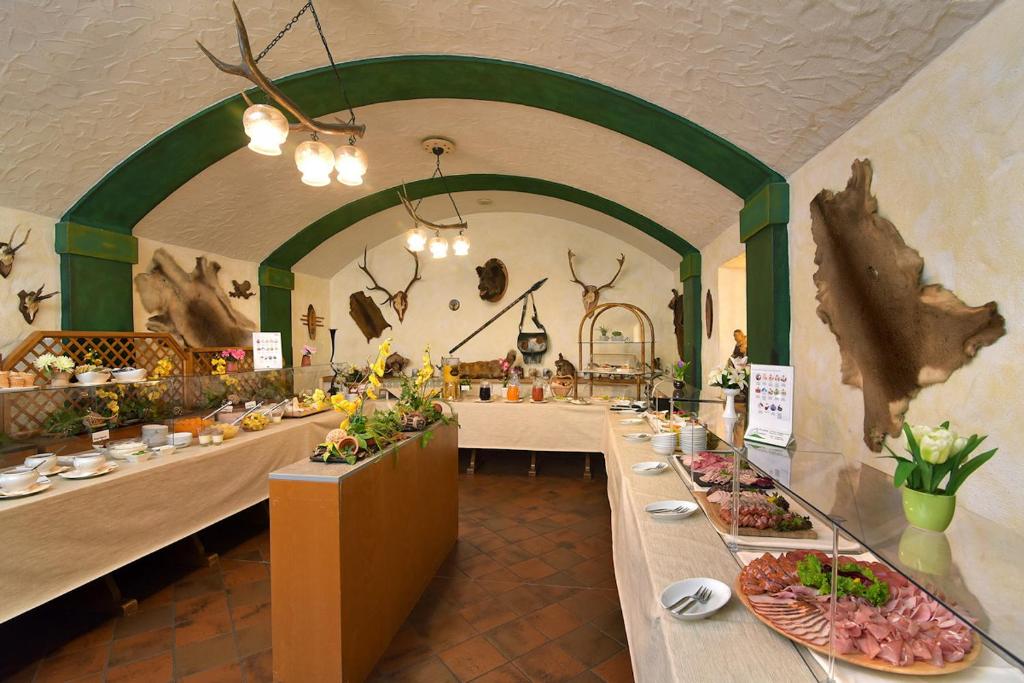 a restaurant with a long table with plates of food at Hotel Am Schlossberg in Ziegenrück