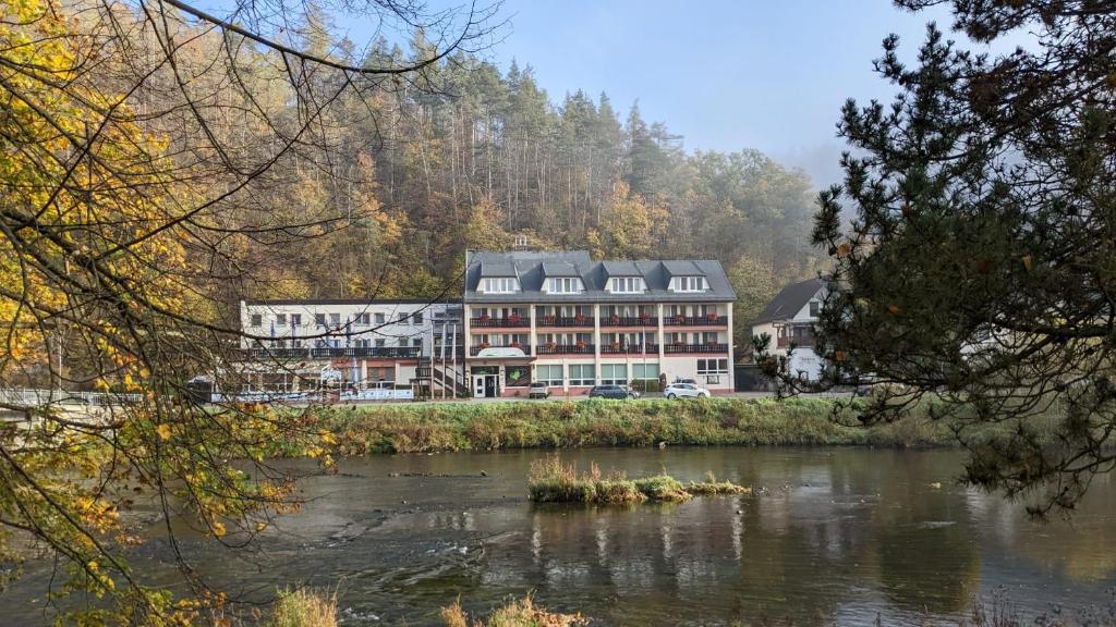 a large building next to a body of water at Hotel Am Schlossberg in Ziegenrück