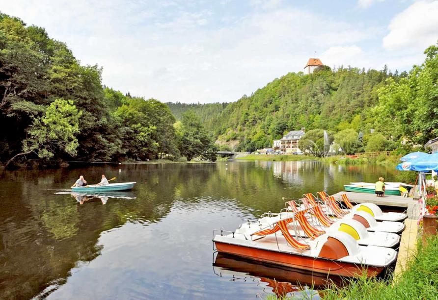 a group of boats are docked on a lake at Hotel Am Schlossberg in Ziegenrück