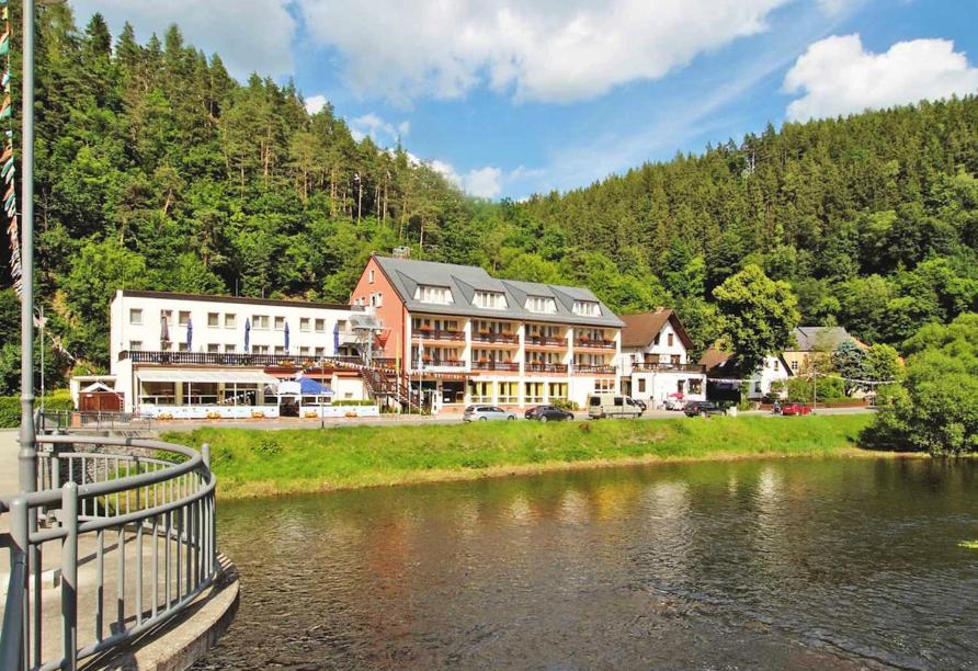 ein großes Gebäude neben einem Wasserkörper in der Unterkunft Hotel Am Schlossberg in Ziegenrück