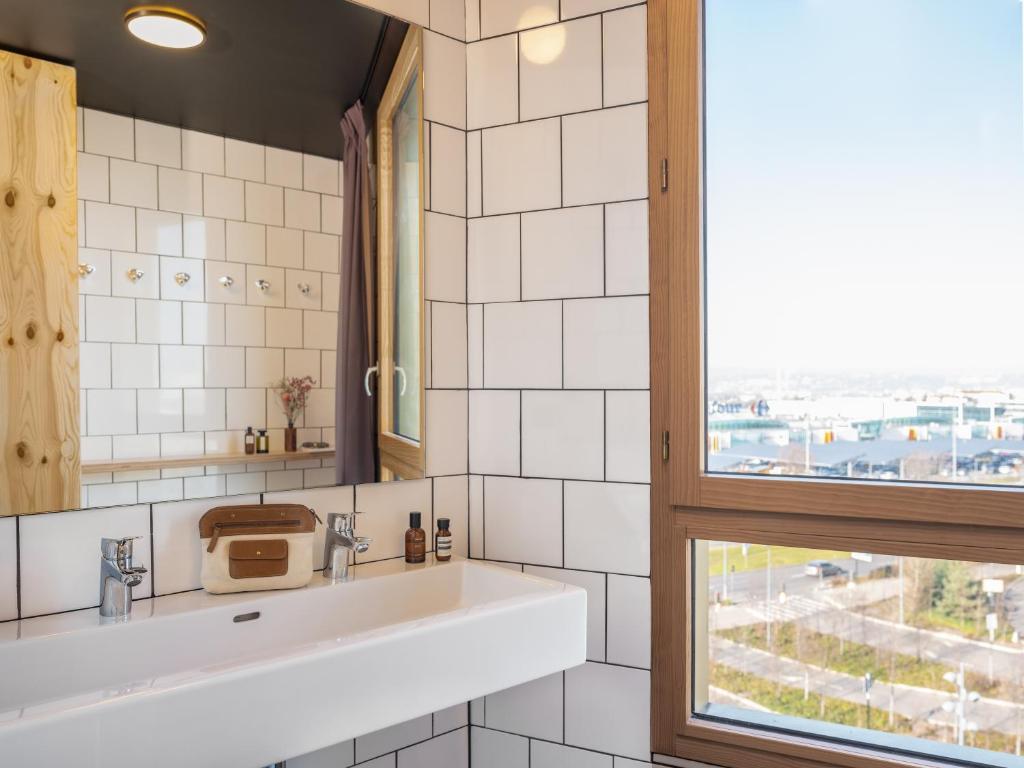 a bathroom with a sink and a window at Eklo Paris Expo Porte de Versailles in Vanves