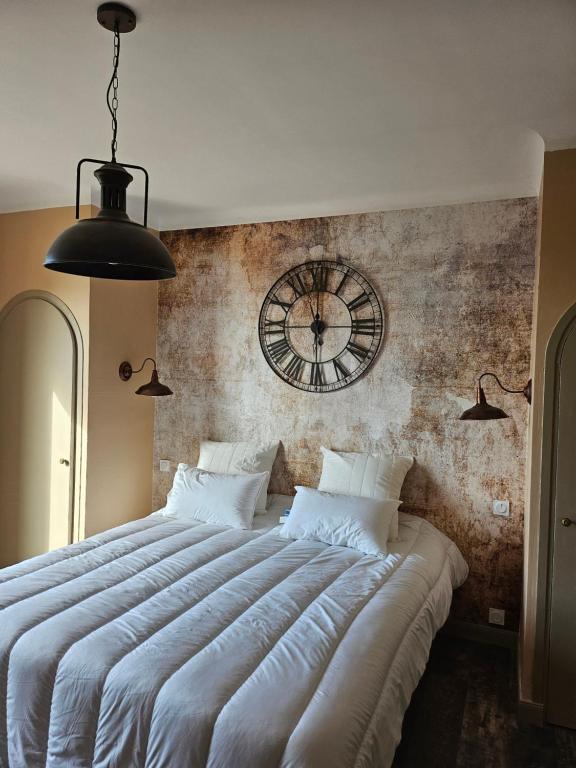 a bedroom with a large bed with a clock on the wall at Chambres d&#39;hôtes Le Montagné in Villeneuve-lès-Avignon