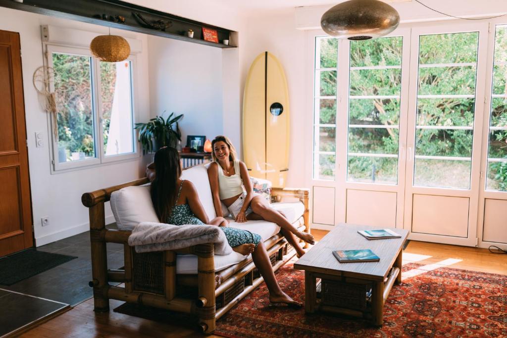 twee vrouwen op een bank in een woonkamer bij JOYU SURF SHACK in Bidart