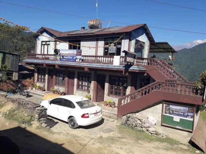 um carro branco estacionado em frente a uma casa em The Hotel Orchid & Restaurant em Kāskī