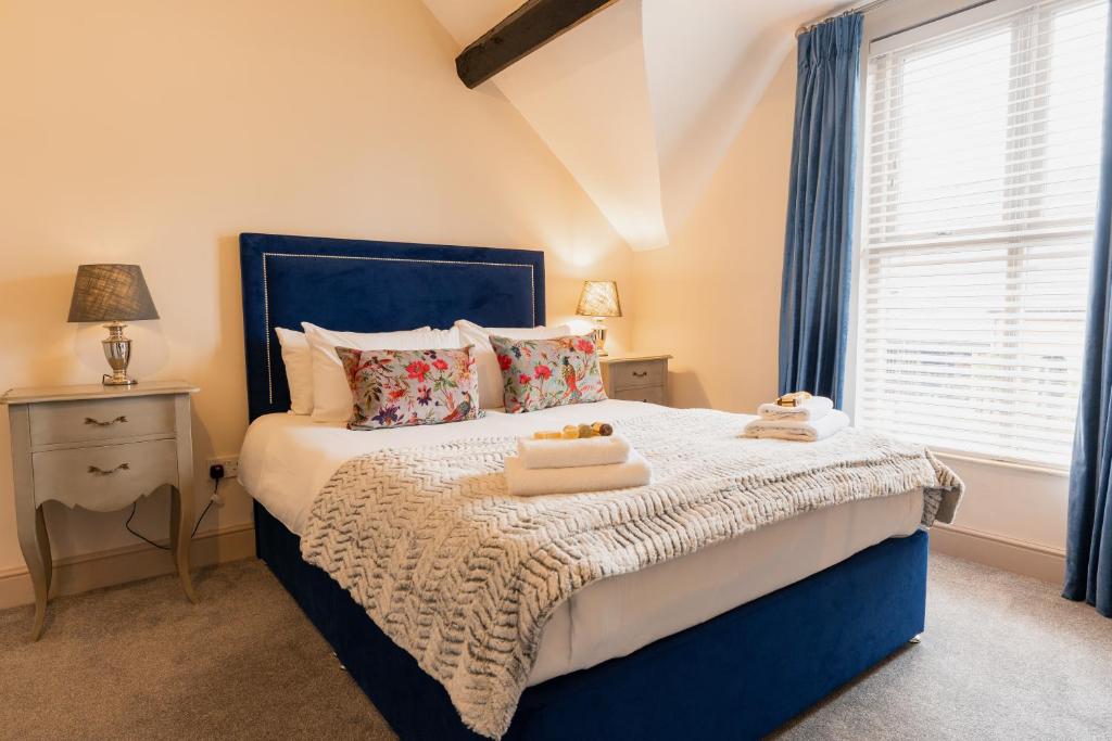 a bedroom with a blue bed with towels on it at Newly renovated 3 bed Tarvin home close to Chester -sleeps up to 11 in Tarvin