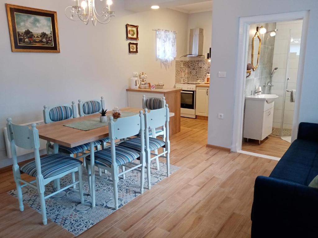 ein Esszimmer und eine Küche mit einem Tisch und Stühlen in der Unterkunft Apartman Katarina Bački Monoštor in Bački Monoštor